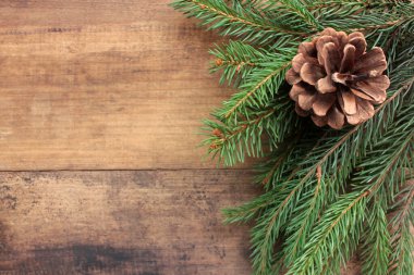 Noel arkaplanı, köknar dalları ve koni. Tahta masa üzerinde yeşil dallar olan kış tatili çerçevesi. Düz yat, boşluğu kopyala