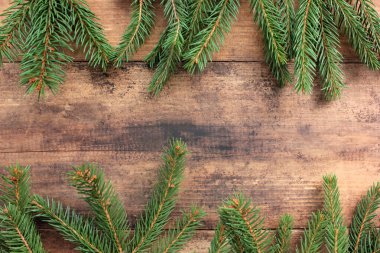 Noel arkaplanı köknar dallarıyla dolu. Tahta masa üzerinde yeşil dallar olan kış tatili çerçevesi. Düz yat, boşluğu kopyala