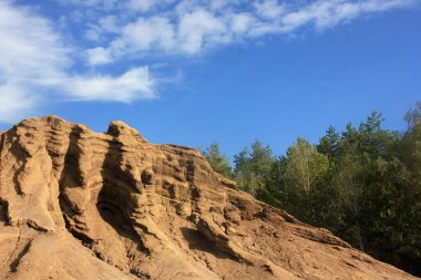 Çöp yığınlarından kömür madenciliği üstüne peyzaj. Açılmış kömür madenciliğinin sonuçları. Mavi gökyüzündeki toprak parçası ve beyaz bulutlar 