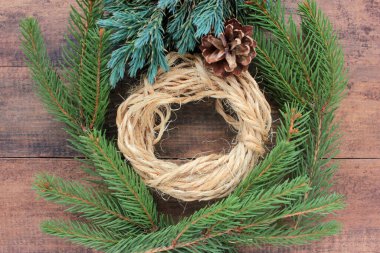 Tahta arka planda Noel çelengi. Kış tatili süslemeleri. Çevre dostu Noel çerçevesi. Üst görünüm, alanı kopyala