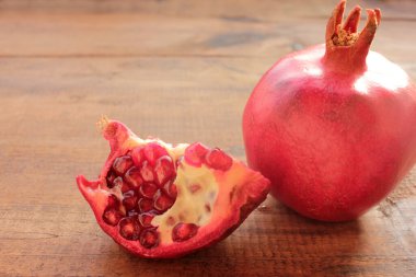 Ahşap zemin üzerinde nar. Ahşap masada olgun taze kırmızı meyve. Üst görünüm, alanı kopyala