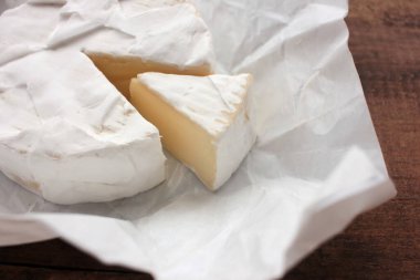 Beyaz ambalaj kağıdına peynirli krema. Üst Manzara. Ahşap arka planda beyaz peyniri kapat