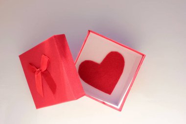 Beyaz masada keçeli kırmızı kalp olan hediye kutusunu aç. Üst görünüm, boşluğu kopyala. Sevgililer Günü konsepti