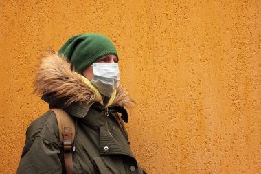 COVID-19 Coronavirus karantinası sırasında şehir sokaklarında salgın koruyucu yüz maskesi takan kadın.