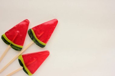 Beyaz arka planda karpuz dondurması. Yaz dönemi. Karpuz şeklinde lolipop. Çubukta şeker. Üst görünüm, alanı kopyala