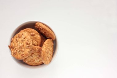 Masadaki kasede fıstık kurabiyesi. Fotokopi alanı olan beyaz arkaplandaki ev yapımı hamur işlerinin genel görünümü