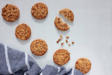 Beyaz arka planda, çizgili gri bez peçeteli taze pişmiş fıstık kurabiyeleri. Genel görünüm, seçici odak