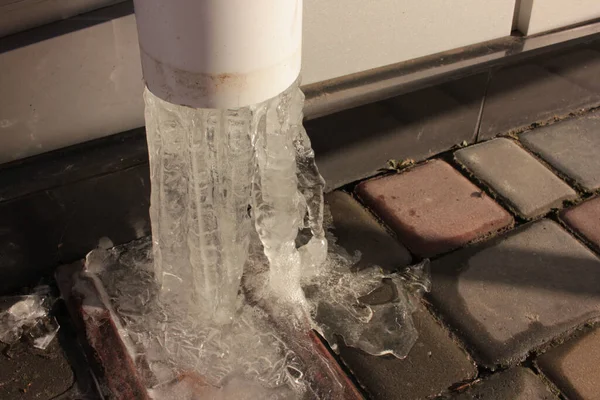 Zmrzlá Voda Bílém Plastovém Dešťovém Potrubí Zlomené Rampouchy Dlažbě Desky — Stock fotografie