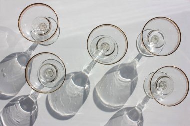 Eski moda coupe manzaralı, geniş, düz şekilli, beyaz arka planda boş şampanya bardakları. Sert ışık, gölgeler. 
