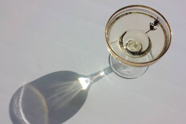 Eski moda coupe, geniş, düz bardaklar, beyaz arka planda altın şampanya şarabı. Sert ışık, gölgeler. Üst görünüm, boşluğu kopyala. Yaz partisi. Güneşli bir gün