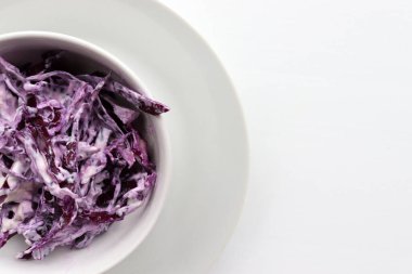 Beyaz masa arka planında kırmızı lahana kabından ev yapımı kremalı lahana salatası. Üst görünüm, boşluğu kopyala. Mayonez soslu taze sebze salatası. Düz yerde yemek vardı. Sağlıklı yeme kavramı