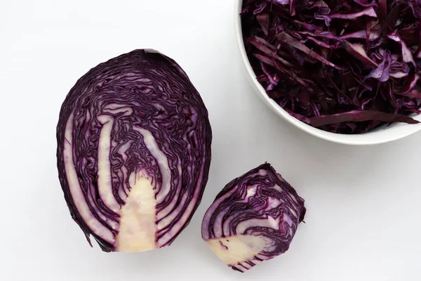 Kâsede kırmızı lahana salatasından ev yapımı lahana salatası ve beyaz masa arkasında malzemeler. Üst görünüm, boşluğu kopyala. Taze sebze salatası. Düz yerde yemek vardı. Sağlıklı yeme kavramı