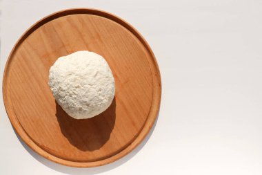 Ahşap tahtada taze yapılmış yumuşak süzme peynirin yakın çekimi. Masada ev yapımı ricotta var. Üst görünüm