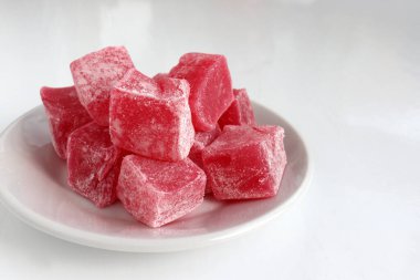 Beyaz masa arkaplanında şeker tozu olan kırmızı Türk lezzetleri. Doğulu tatlı tatlı tatlı rahat locum. Üst görünüm, alanı kopyala