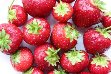 Strawberries on a plate. Fresh organic summer red berries on white background. Top view, copy space