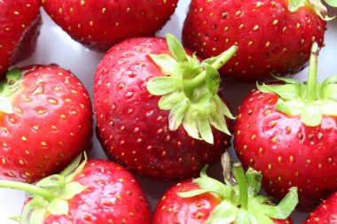 Strawberries on a plate. Fresh organic summer red berries on white background. Top view, copy space