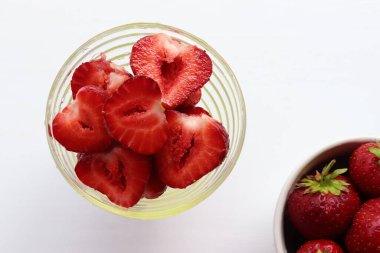 Strawberries on a plate. Fresh organic summer red berries on white background. Top view, copy space
