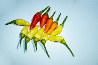 Beyaz arka planda beyaz kırmızı ve turuncu kırmızı biberler