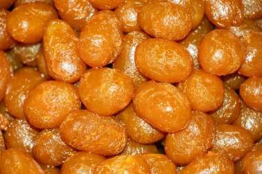 Yakın çekim, yüksek açılı geleneksel Asya tatlıları yığını, büyük ihtimalle Gulab Jamun ya da lezzetli Langcha gibi lezzetli bir şuruba batırılmış lezzet.
