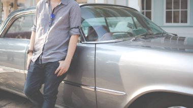 Antika arabanın yanında duran genç adam - kullanılmış araba ya da kiralık araba konsepti.