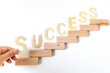 Merdivenler olarak ahşap blokları dizmeye odaklan. Büyüme süreci için iş konsepti. Kariyer artışının sembolü olan merdivenler ya da iş başarısı. Kelime SUCCESS yazıldı.