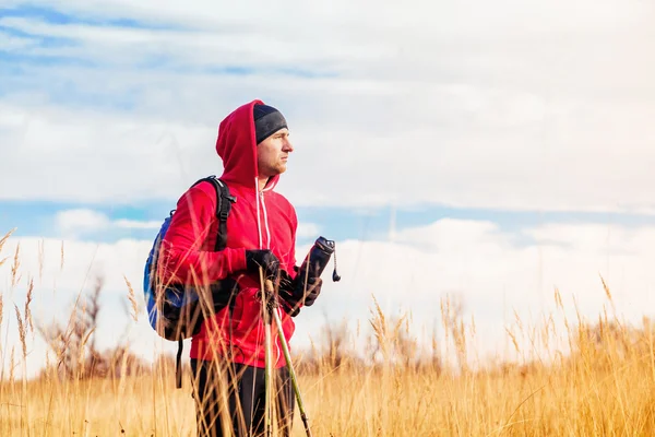 Homme randonneur avec sac à dos debout sur le terrain et regardant paysage pittoresque de terrain — Photo