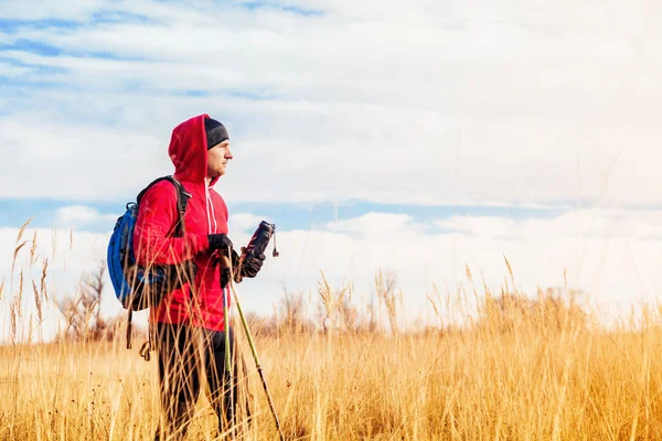 Portret człowieka wycieczkowicz stoi w polu i patrząc na krajobraz malowniczego pola — Zdjęcie stockowe