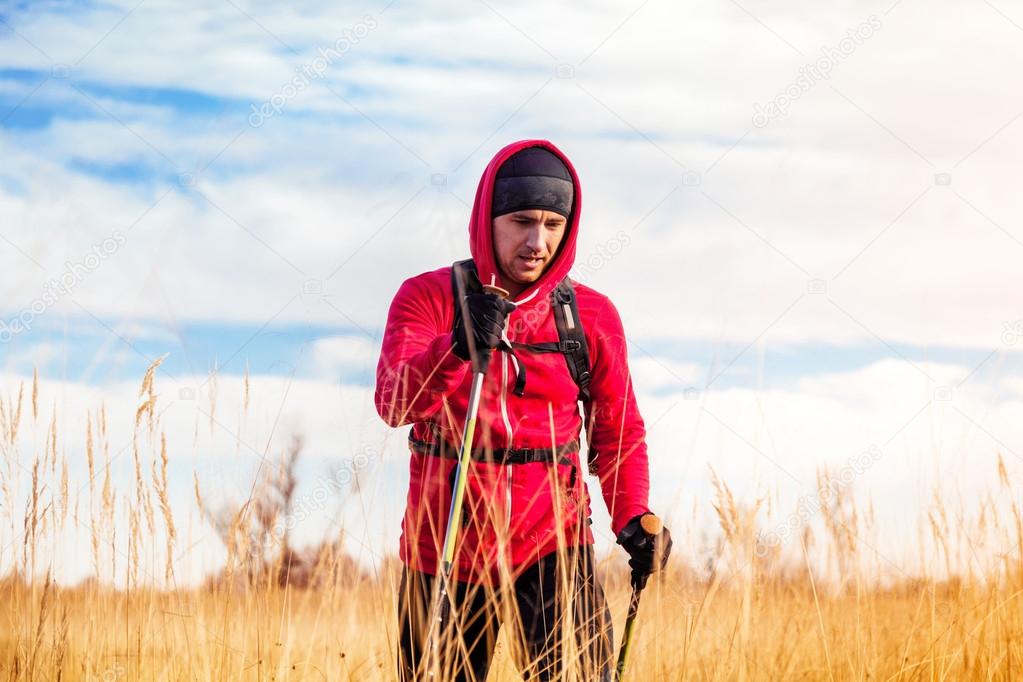 Portrait of hiker man walking in a scenic field landscape