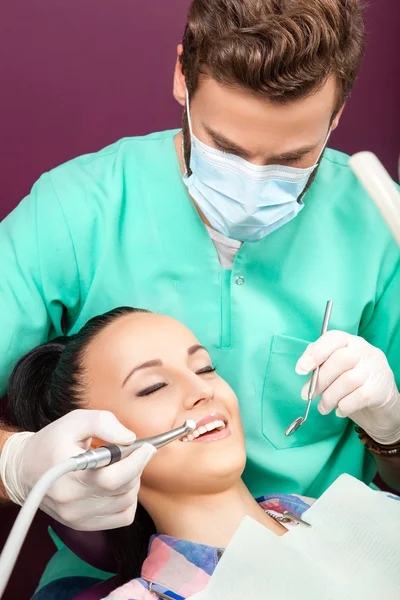 El dentista masculino examina la boca de la mujer en la silla del dentista — Foto de Stock