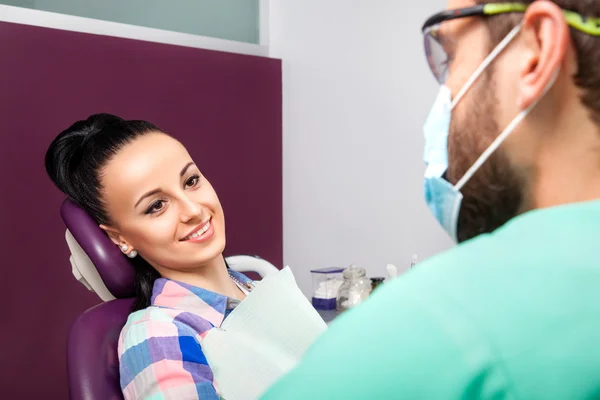 Dentista masculino falando com mulher bonita paciente na clínica odontológica — Fotografia de Stock