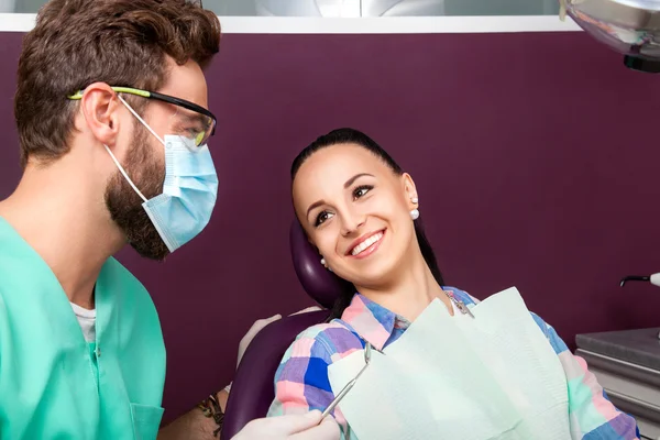 Frau mit weißen Zähnen und Zahnarzt lächeln einander an — Stockfoto