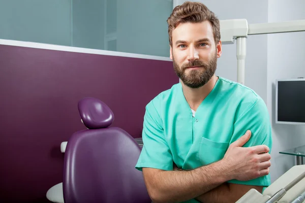 Médico masculino com barba em traje verde na clínica odontológica — Fotografia de Stock