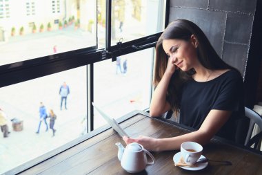 Kafede tablet bilgisayarda çalışan genç kız