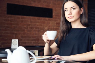 Kafede çay içme ve Kupası tutan genç kız