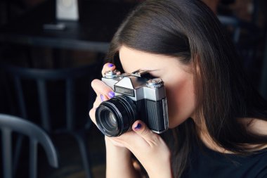 Genç kız fotoğrafçı ile eski analog kamera Cafe
