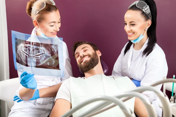Dentista mostra um paciente raio-X dos dentes — Fotografia de Stock