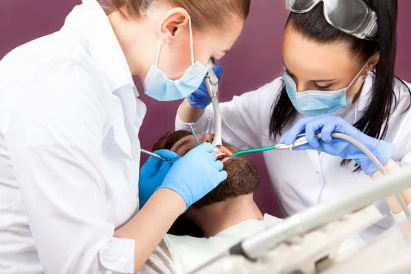 Mujer dentista médico hace revisión de dientes para los hombres pacientes —  Fotos de Stock