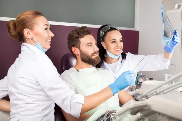 El dentista muestra una radiografía de dientes del paciente — Foto de Stock