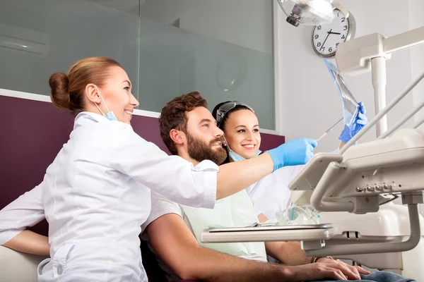 El dentista muestra una radiografía de dientes del paciente — Foto de Stock