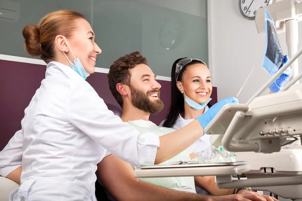 El dentista muestra una radiografía de dientes del paciente — Foto de Stock