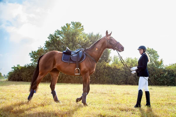 Vackra jockey girl stå bredvid sin häst. — Stockfoto