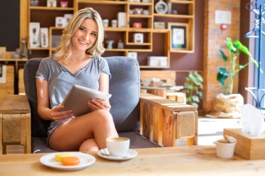 Kahve dükkanında tablet bilgisayar kullanan genç hippi kız