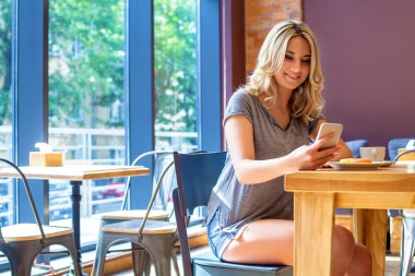 Genç gülümseyen kız bir şey ona telefon okuyun