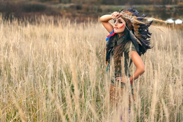 Native American Indian flicka klädd i nationella kläder och tittar på fältet sommaren — Stockfoto