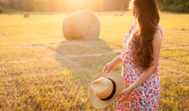 Woman in a hat with curly hair moving up in the field