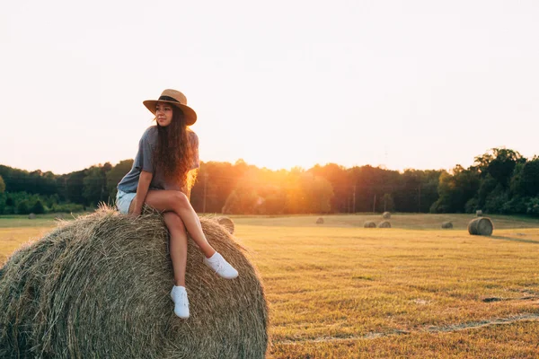 Woman sitting on hay bale — Stock Photo, Image