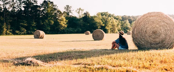 Donna nel campo con palle di fieno — Foto Stock