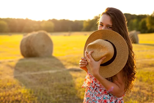 Woman in a hat with curly hair moving up in the field — Stock Photo, Image