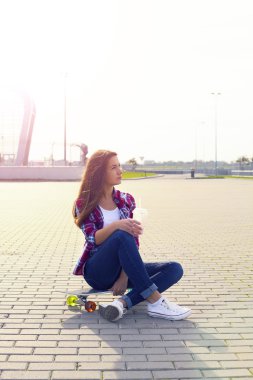 Bir kaykay ve milkshake olan güzel kadın