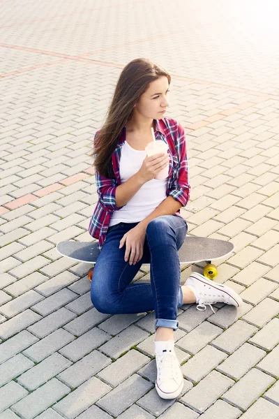 Krásná mladá žena s skateboard a koktejl — Stock fotografie